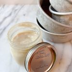 jar of gluten free cake release sitting on a marble counter with cake pans in the background
