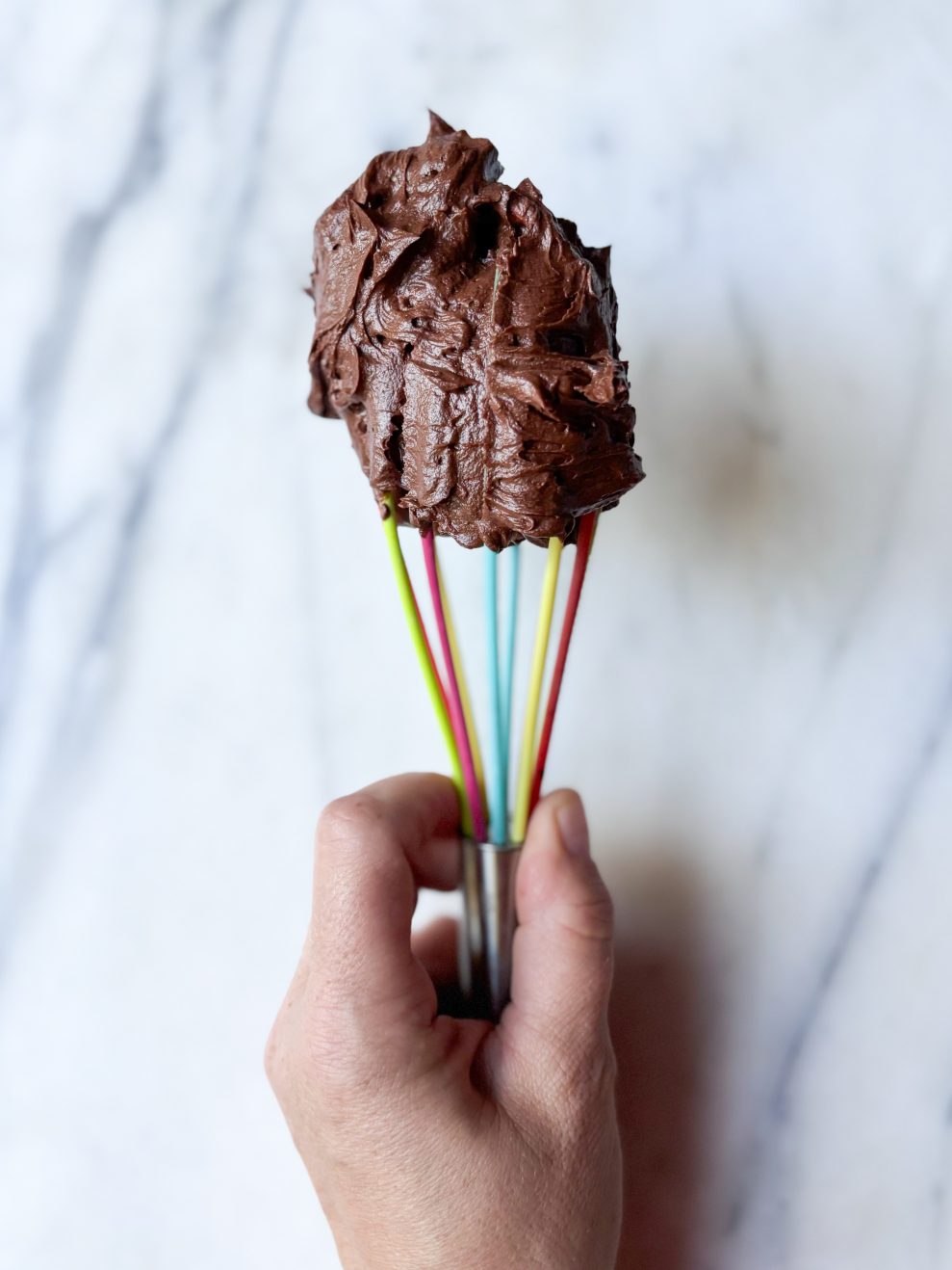 rainbow whisk with a dollop of chocolate american style buttercream on the top